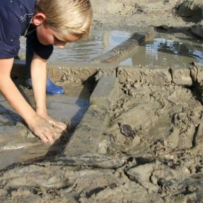 2 spelende kinderen in een modderpoel 